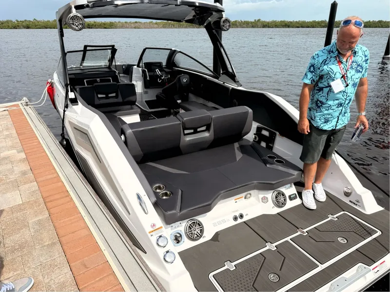 Slide: The Image of A modern 2026 Scarab 285 LX is docked. A man stands beside it. - 7