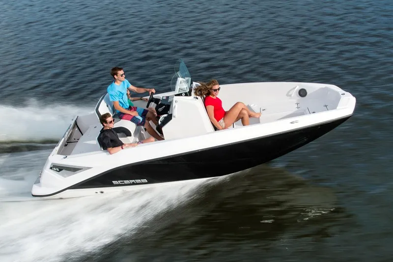 The Image of A 2019 Scarab 195 Open G boat speeding across the water with three people on board. - 1