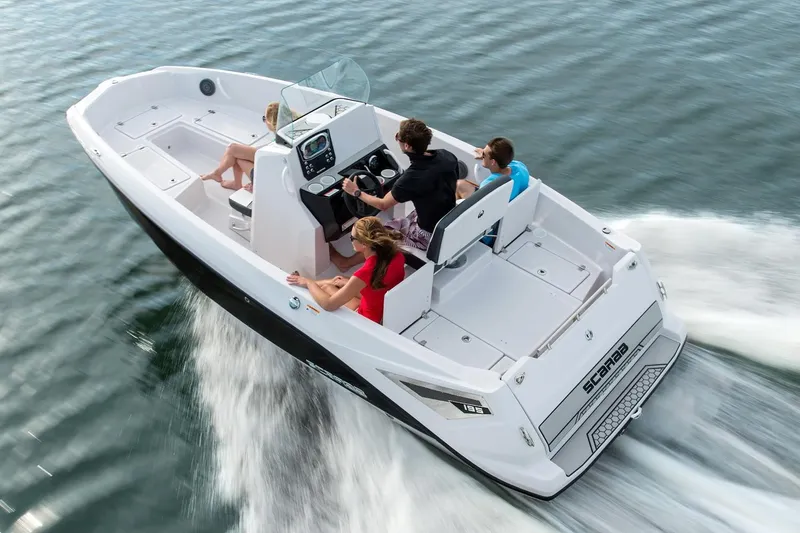 Slide: The Image of A 2019 Scarab 195 Open G boat speeds across the water. Four people are on board. - 3