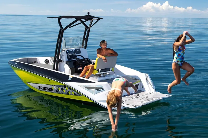 Slide: The Image of A 2019 Scarab 195 Open ID boat on calm water. Two children are jumping into the water. - 10