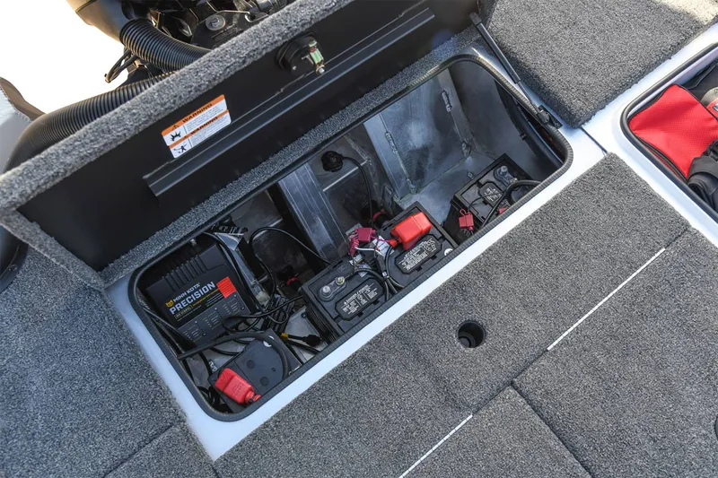 Slide: The Image of The image shows the battery compartment area of a 2024 Vexus Boats AVX1880 with batteries and charger. - 14