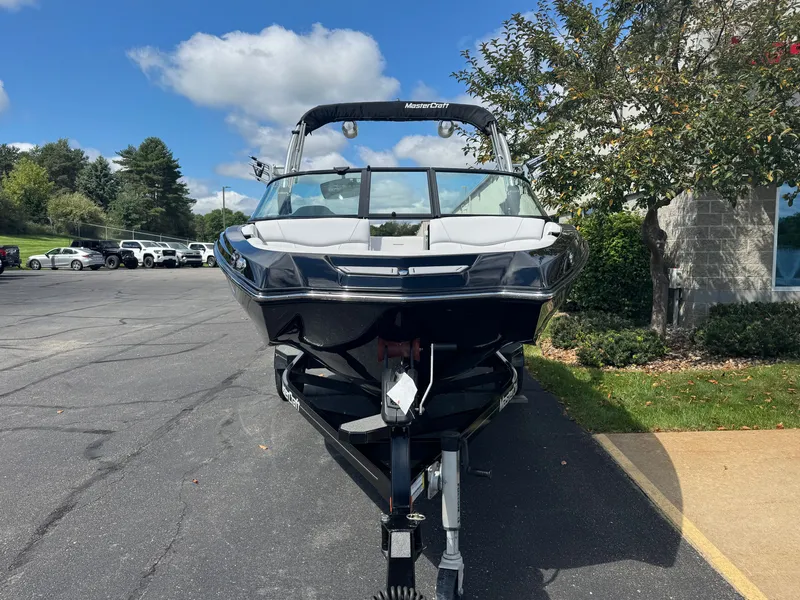 Slide: The Image of A black 2020 MasterCraft NXT20 boat on a trailer in a parking lot. - 3