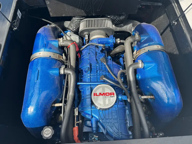 Slide: The Image of The engine compartment of a 2020 MasterCraft NXT20 features a powerful Ilmor engine with blue covers. - 18