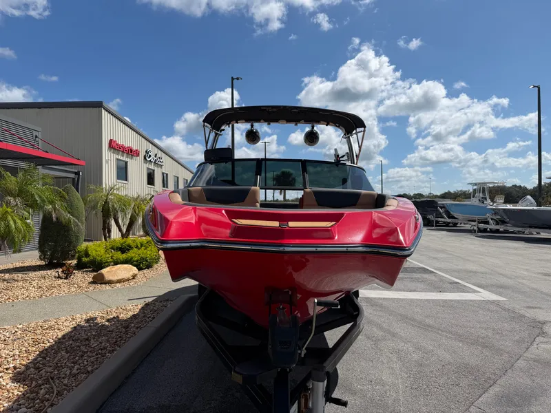 Slide: The Image of A red 2022 MasterCraft NXT24 boat on a trailer in front of a building. - 3