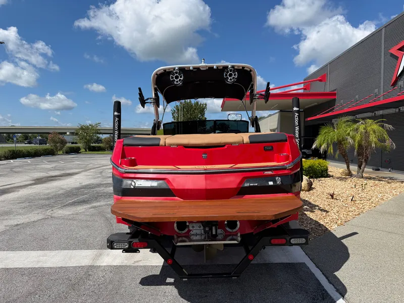 Slide: The Image of A red 2022 MasterCraft NXT24 boat is parked, featuring a wooden platform at the rear. - 6