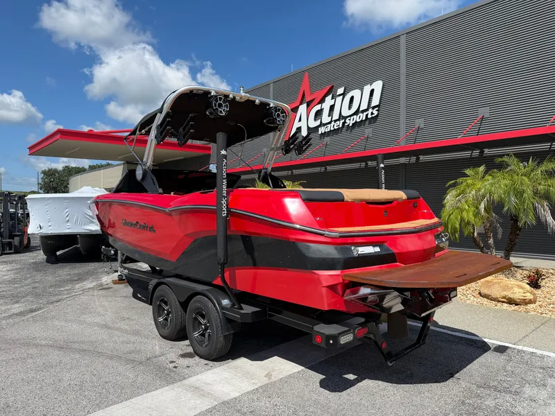 Slide: The Image of A red 2022 MasterCraft NXT24 boat on a trailer outside a water sports store. - 7