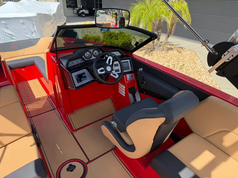 Slide: The Image of The image shows the cockpit of a 2022 MasterCraft NXT24 with red and beige interior. - 14