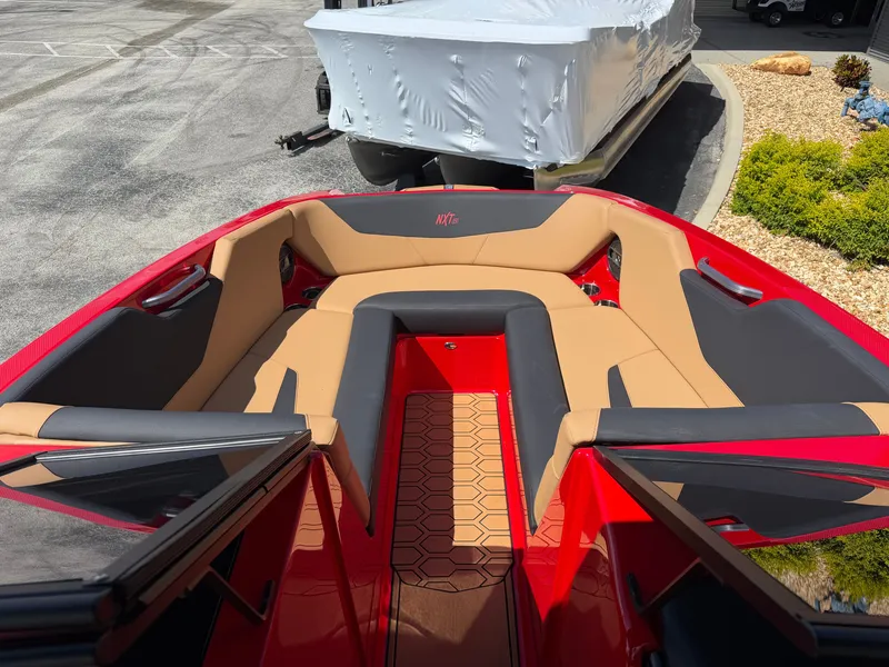 Slide: The Image of The image shows the bow of a 2022 MasterCraft NXT24 with red and beige upholstery. - 9