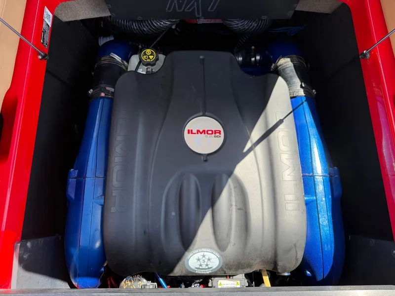 Slide: The Image of The engine compartment of a 2022 MasterCraft NXT24 features an Ilmor engine with blue hoses. - 16