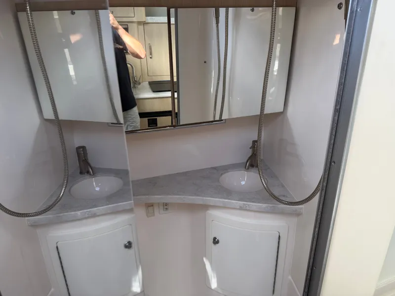 Slide: The Image of The image shows a modern boat bathroom with two sinks and mirrors. - 19