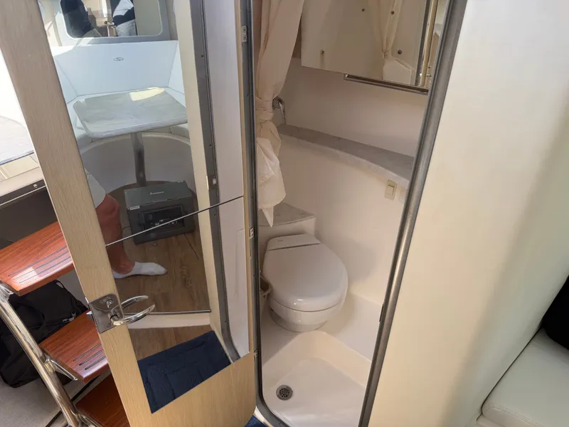 Slide: The Image of The image shows the bathroom of a 2023 Regal 28 Express with a toilet and shower. - 18