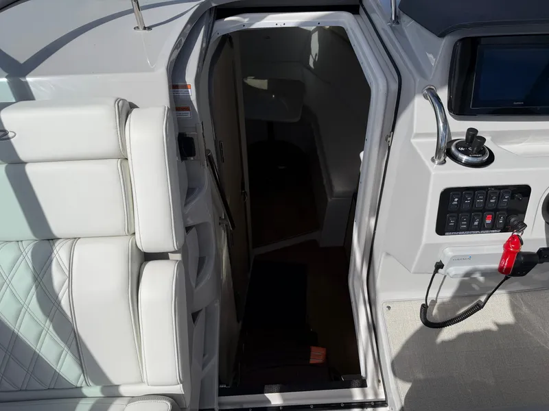 Slide: The Image of The 2023 Regal 28 Express features a cabin entrance with white upholstery and a helm console. - 16