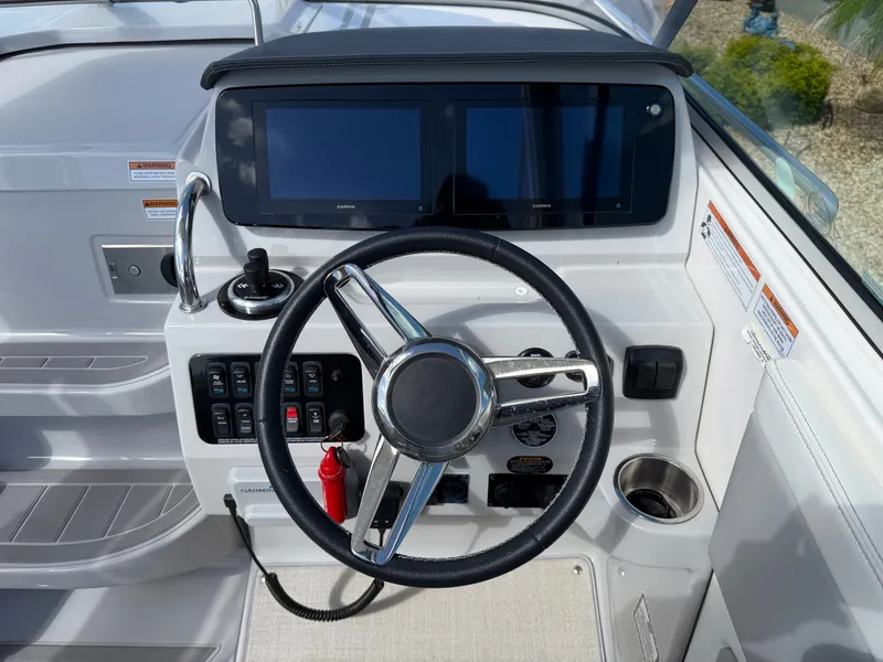 Slide: The Image of The cockpit of the 2023 Regal 28 Express features a modern steering wheel and digital displays. - 14