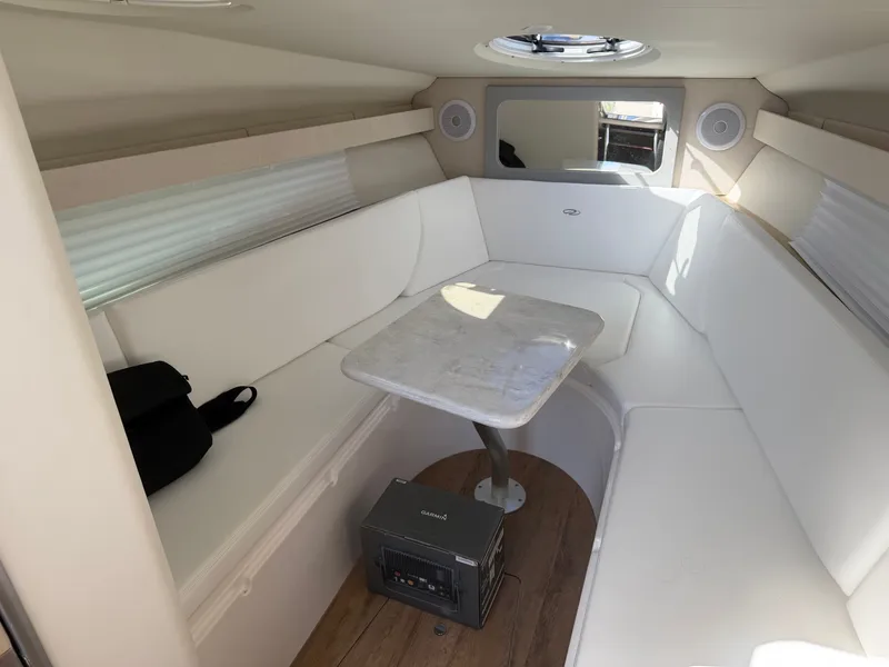 Slide: The Image of Interior of a 2023 Regal 28 Express with white seating area and table. - 17