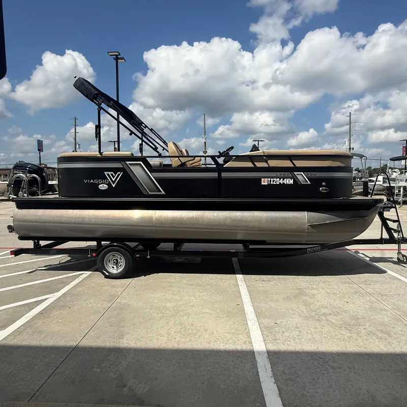 Slide: The Image of A 2022 Viaggio L20U pontoon boat on a trailer, featuring a black hull and beige interior. - 7