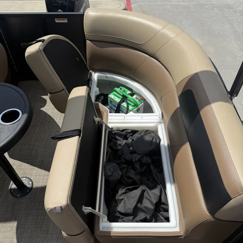 Slide: The Image of An open storage compartment under a boat seat reveals batteries and covers. - 21