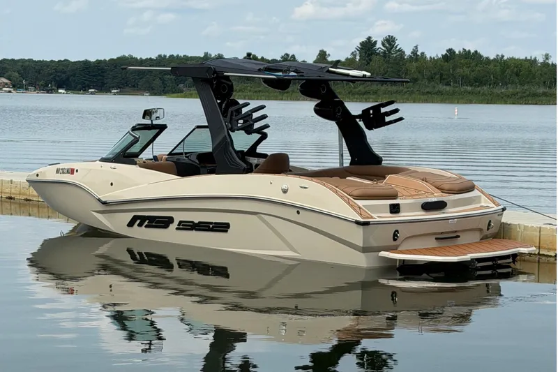 The Image of A sleek motorboat with a modern design docked at a calm lakeside. - 1
