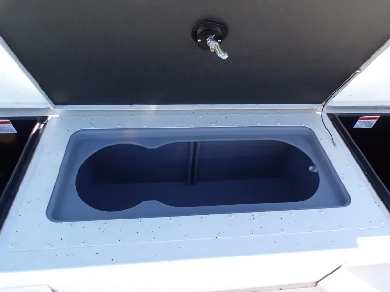 Slide: The Image of An open storage compartment on a 2018 G3 Bay 18 boat, featuring a gray, elongated container. - 16