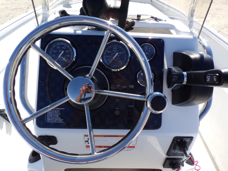 Slide: The Image of The image shows the helm of a 2018 G3 Bay 18 boat with instruments and a throttle. - 23