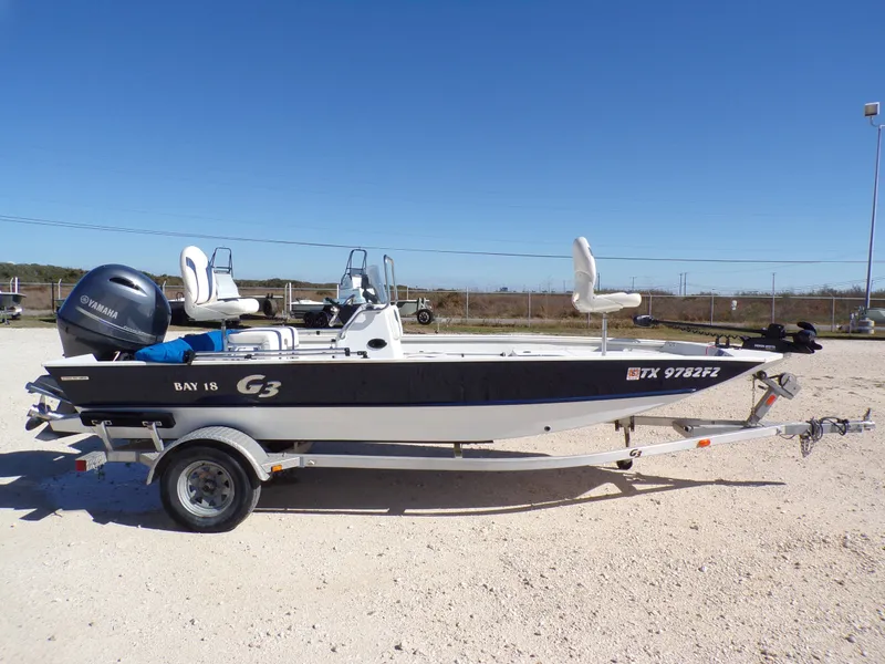 Slide: The Image of A 2018 G3 Bay 18 boat on a trailer, featuring a Yamaha outboard motor. - 12