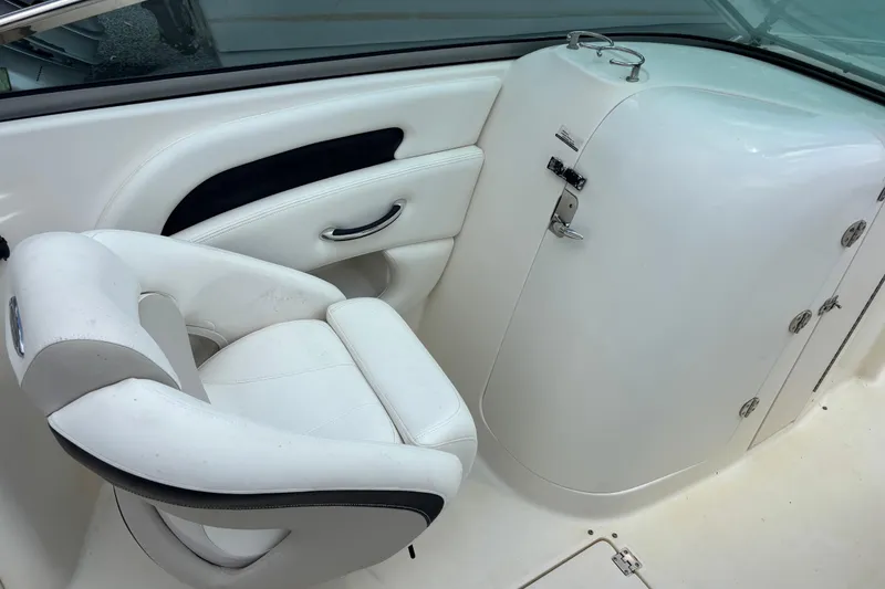 Slide: The Image of Interior of 2008 Chaparral 236 SSX boat featuring white seating and storage compartment. - 12