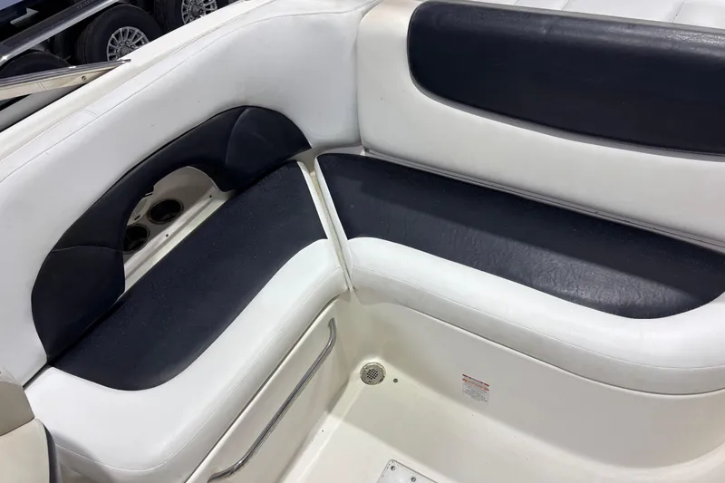 Slide: The Image of Interior seating of a 2008 Chaparral 236 SSX boat, featuring black and white upholstery. - 7