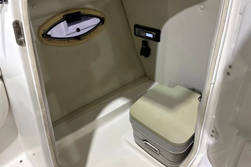 Slide: The Image of Interior of 2008 Chaparral 236 SSX boat with compact toilet and porthole window. - 16
