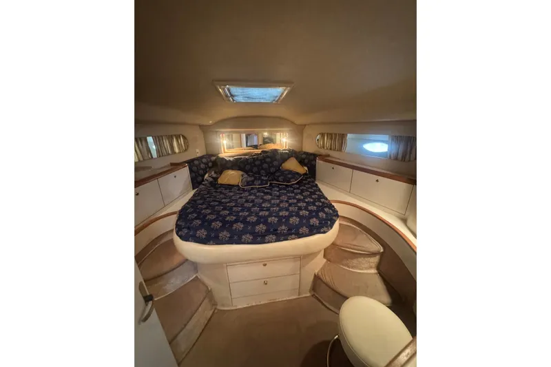 Slide: The Image of Luxurious 1997 Sea Ray 420 Aft Cabin bedroom with cozy bedding and elegant design. - 11