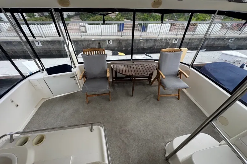 Slide: The Image of 1997 Sea Ray 420 Aft Cabin yacht interior with chairs and table on deck. - 4