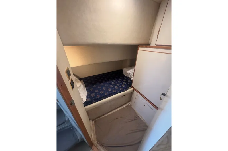 Slide: The Image of 1997 Sea Ray 420 Aft Cabin interior with cozy bed and storage. - 12