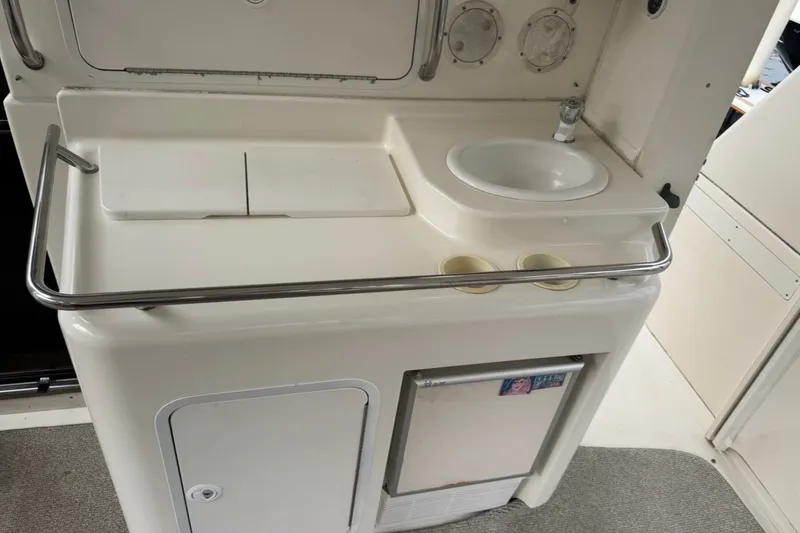 Slide: The Image of 1997 Sea Ray 420 Aft Cabin kitchenette with sink, storage, and mini fridge. - 15