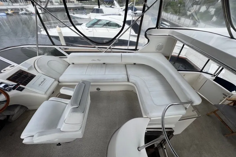 Slide: The Image of 1997 Sea Ray 420 Aft Cabin yacht interior with white seating and helm station. - 3