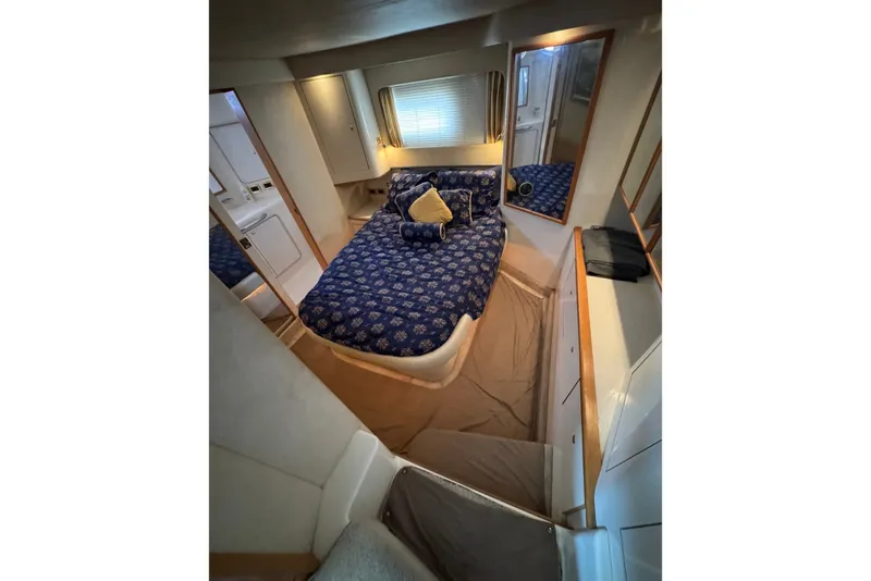 Slide: The Image of Luxurious 1997 Sea Ray 420 Aft Cabin bedroom with blue bedding and elegant decor. - 10