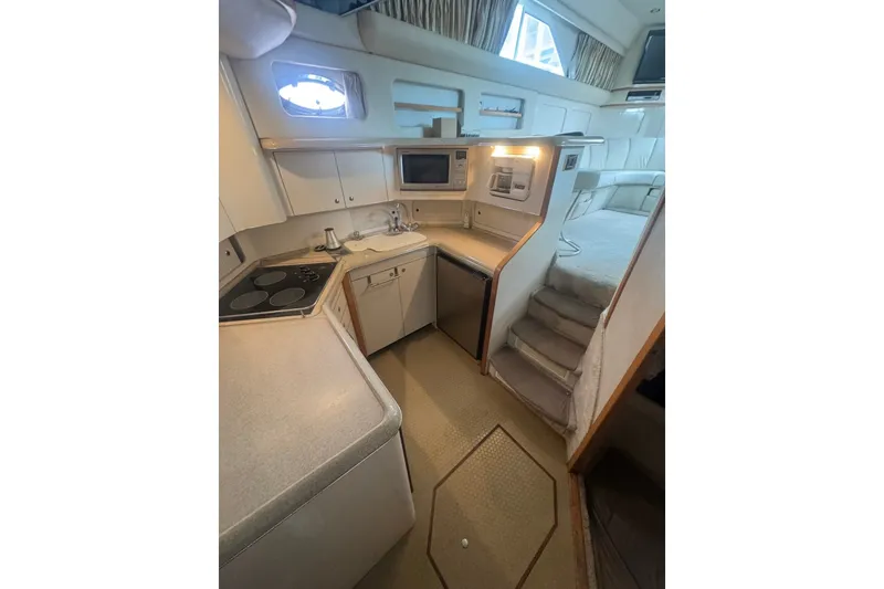 Slide: The Image of Interior of 1997 Sea Ray 420 Aft Cabin yacht, featuring kitchen and cozy living space. - 9
