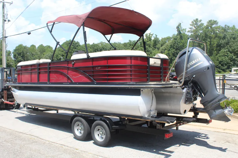 Slide: The Image of A red 2016 Bennington pontoon boat with a Yamaha outboard motor on a trailer. - 3