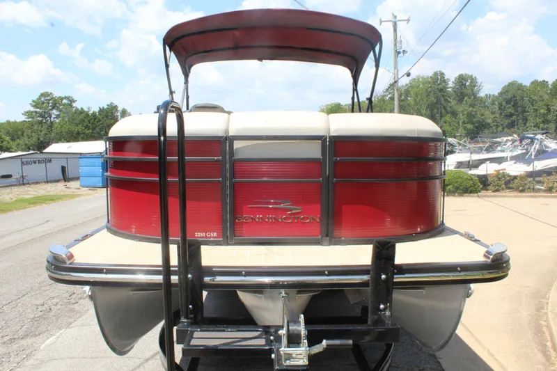 Slide: The Image of A 2016 Bennington 2250GSR pontoon boat with a red hull and black bimini top. - 4