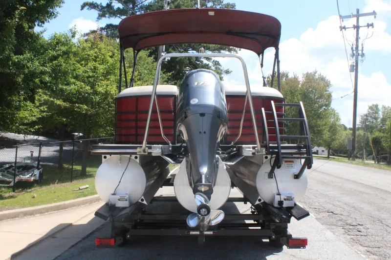 Slide: The Image of A 2016 Bennington 2250GSR pontoon boat on a trailer, featuring a red canopy and outboard motor. - 5