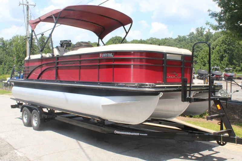 Slide: The Image of A red 2016 Bennington 2250GSR pontoon boat on a trailer, featuring a canopy and railings. - 8