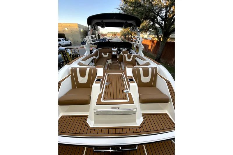 Slide: The Image of 2021 MB F24 Tomcat Alpha boat interior with brown and white seating, wood-style flooring. - 13