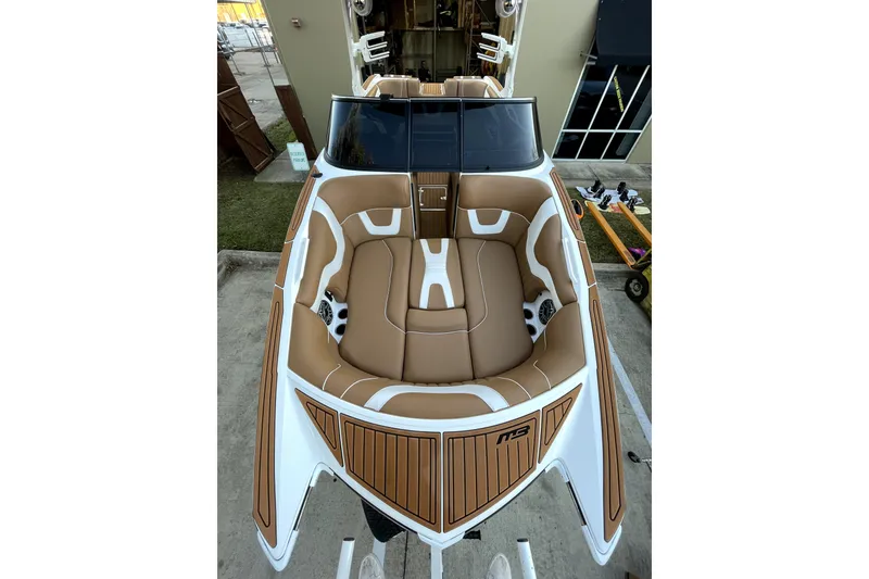Slide: The Image of 2021 MB F24 Tomcat Alpha boat with tan and white seating, docked outdoors. - 12