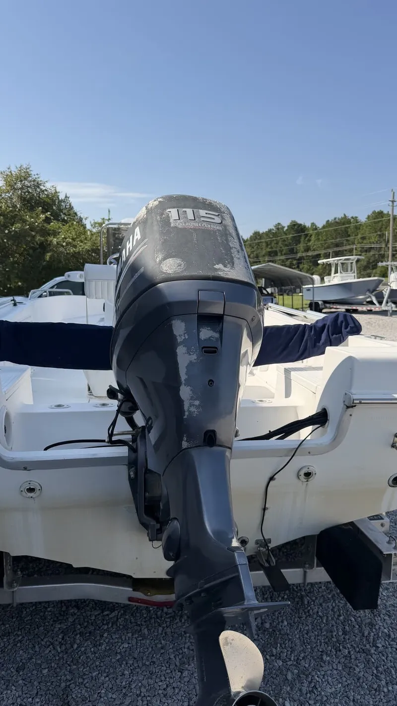 Slide: The Image of A 2010 Clearwater 1900 Center Console boat with a Yamaha outboard motor, parked on a gravel lot. - 5