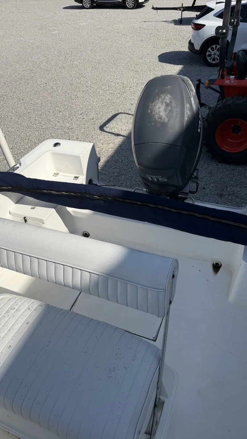 Slide: The Image of A 2010 Clearwater 1900 Center Console boat with an outboard motor, parked on a gravel lot. - 7