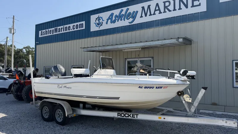 Slide: The Image of A white 2010 Clearwater 1900 Center Console boat on a trailer in front of a building. - 2