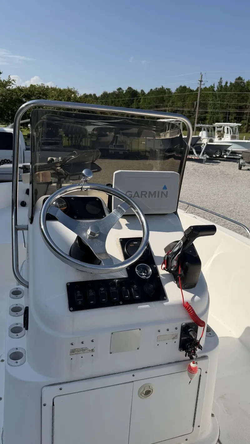 Slide: The Image of The image shows the helm of a 2010 Clearwater 1900 Center Console boat. It features a Garmin navigation system and various controls. - 4