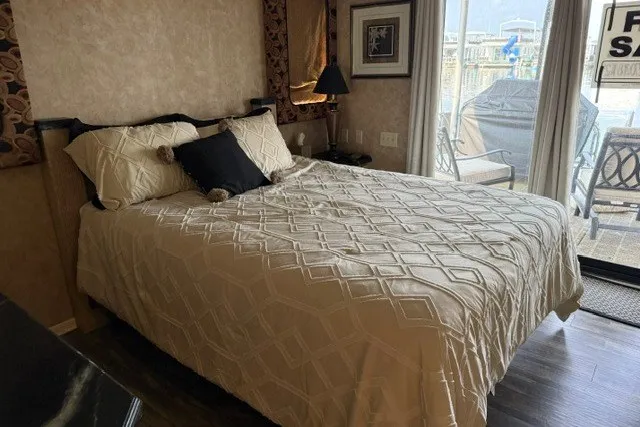Slide: The Image of Cozy bedroom in a 1995 Stardust Cruisers 18 x 65 houseboat with elegant decor and marina view. - 23