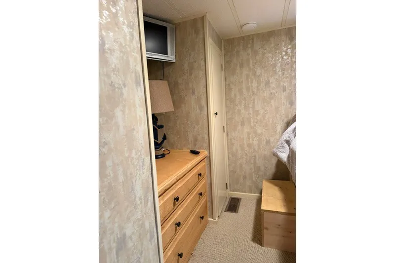 Slide: The Image of Cozy interior of 1995 Stardust Cruisers houseboat with dresser and TV. - 18
