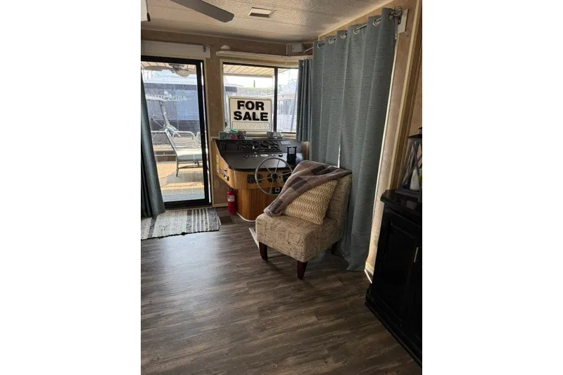 Slide: The Image of 1995 Stardust Cruisers 18 x 65 houseboat interior with "For Sale" sign, cozy seating area. - 13