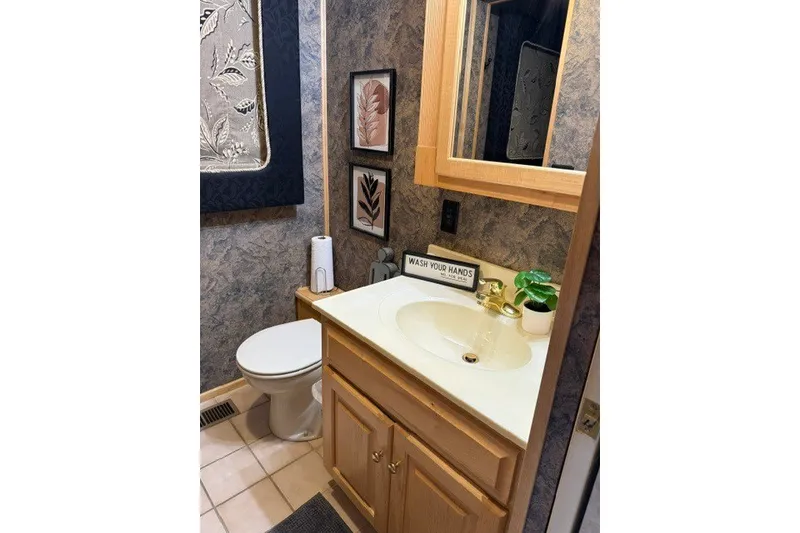 Slide: The Image of Bathroom interior of 1995 Stardust Cruisers 18 x 65 houseboat, featuring sink and decor. - 19