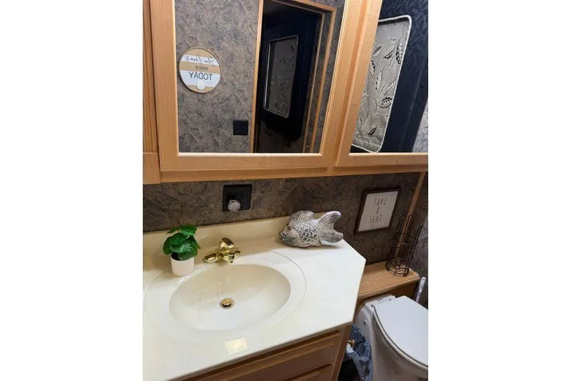 Slide: The Image of Bathroom interior of 1995 Stardust Cruisers houseboat with sink, mirror, and decor. - 22