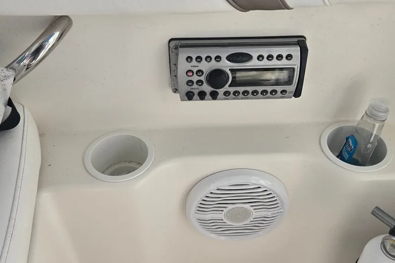 Slide: The Image of 2004 Wellcraft 252 Coastal boat console with stereo, cup holders, and speaker. - 16